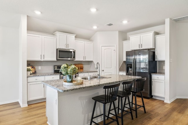 107 Nathaniel Dr, Taylor, TX 76574 - kitchen featuring appliances with stainless steel finishes, a sink, white cabinets, and recessed lighting