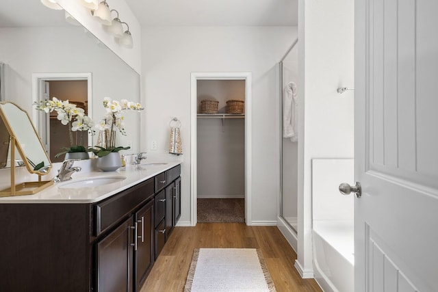 107 Nathaniel Dr, Taylor, TX 76574 - full bath with wood finished floors, an enclosed shower, double vanity, and a tub to relax in