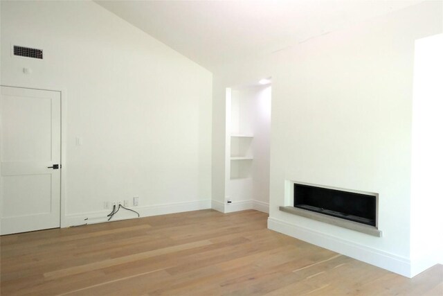 808 Vanguard St, Lakeway, TX 78734 - unfurnished living room featuring a fireplace, wood finished floors, and vaulted ceiling