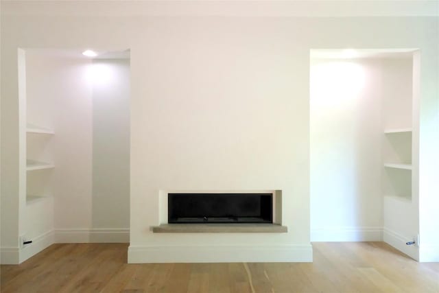 808 Vanguard St, Austin, TX 78734 - unfurnished living room with wood finished floors, built in shelves, and baseboards