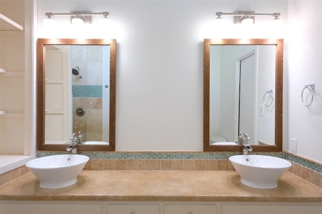808 Vanguard St, Lakeway, TX 78734 - bathroom featuring double vanity, tiled shower, and backsplash