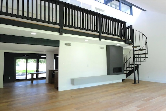 808 Vanguard St, Austin, TX 78734 - unfurnished living room with a towering ceiling, wood finished floors, baseboards, stairway, and recessed lighting