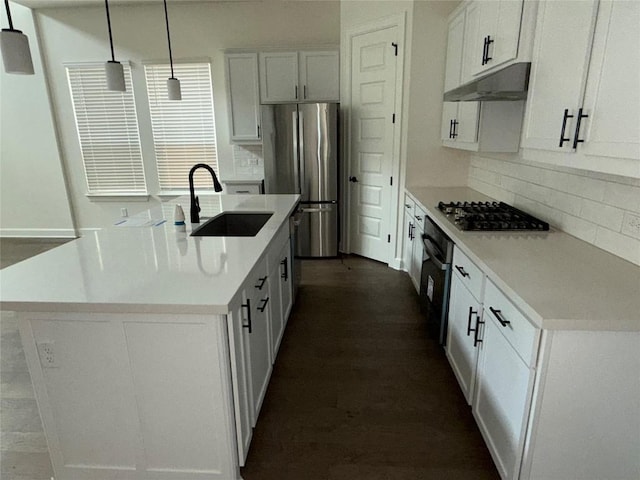 245 Darley Oak Dr, Dripping Springs, TX 78620 - kitchen featuring under cabinet range hood, gas cooktop, a sink, freestanding refrigerator, and backsplash