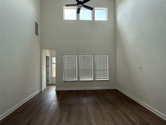 245 Darley Oak Dr, Dripping Springs, TX 78620 - unfurnished living room featuring a ceiling fan, baseboards, healthy amount of natural light, dark wood-style flooring, and a high ceiling