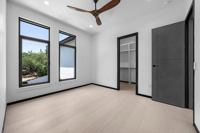 101 S Lake Hills Dr, Austin, TX 78733 - unfurnished bedroom with light wood-type flooring, recessed lighting, a walk in closet, baseboards, and ceiling fan