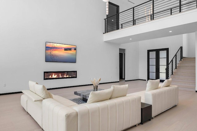 101 S Lake Hills Dr, Austin, TX 78733 - living area featuring a towering ceiling, a glass covered fireplace, wood finished floors, and stairway