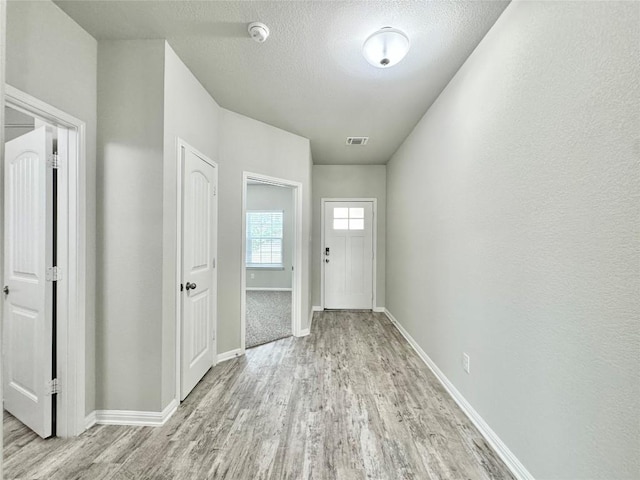 2721 Bridekirk Dr, Round Rock, TX 78664 - doorway to outside featuring wood finished floors, baseboards, and a textured ceiling