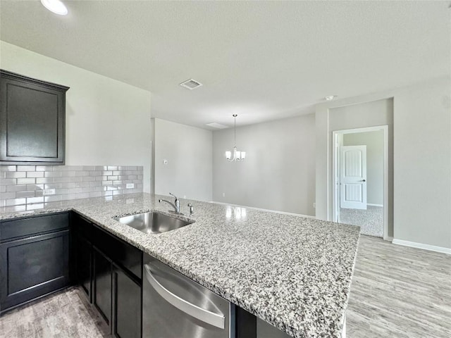 2721 Bridekirk Dr, Round Rock, TX 78664 - kitchen featuring dishwasher, a sink, a peninsula, light stone counters, and light wood-type flooring