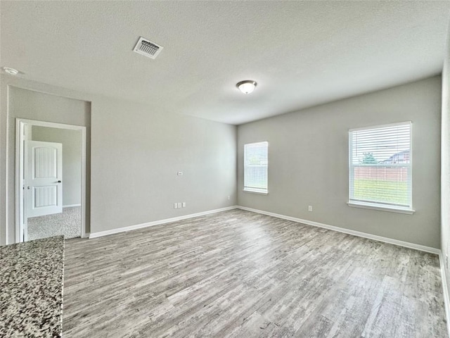 2721 Bridekirk Dr, Round Rock, TX 78664 - spare room featuring wood finished floors, baseboards, and a textured ceiling