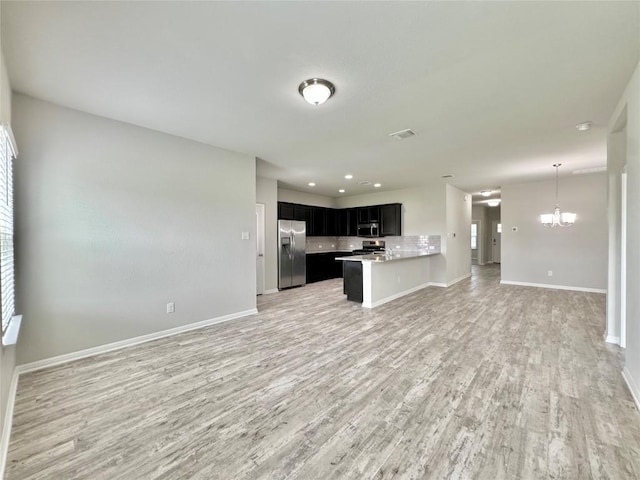 2721 Bridekirk Dr, Round Rock, TX 78664 - unfurnished living room featuring light wood-style flooring, baseboards, a chandelier, and recessed lighting