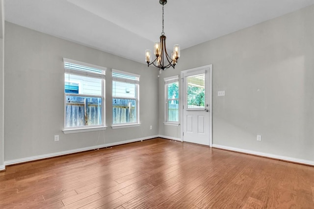 204 Chickadee Ln, Leander, TX 78641 - unfurnished dining area with a chandelier, healthy amount of natural light, wood finished floors, and baseboards