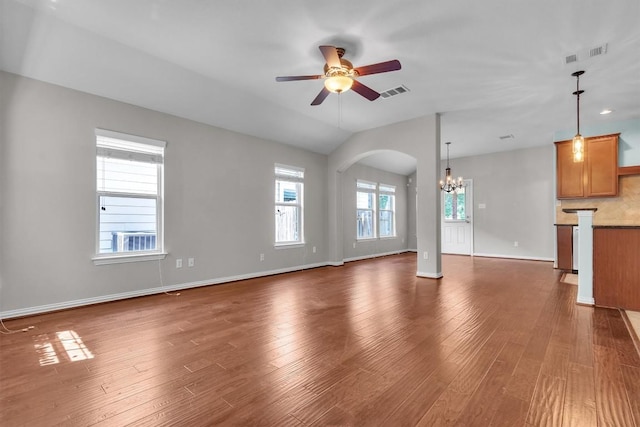 204 Chickadee Ln, Leander, TX 78641 - unfurnished living room featuring a chandelier, arched walkways, ceiling fan, dark wood finished floors, and vaulted ceiling