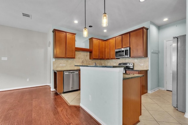 204 Chickadee Ln, Leander, TX 78641 - kitchen with appliances with stainless steel finishes, backsplash, a center island, pendant lighting, and recessed lighting