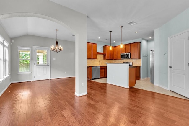 204 Chickadee Ln, Leander, TX 78641 - kitchen featuring stainless steel appliances, light wood-style floors, a chandelier, brown cabinets, and open floor plan