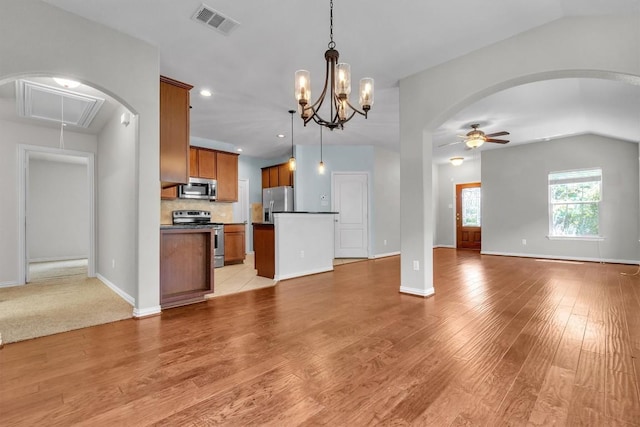 204 Chickadee Ln, Leander, TX 78641 - kitchen with open floor plan, appliances with stainless steel finishes, ceiling fan, brown cabinetry, and vaulted ceiling