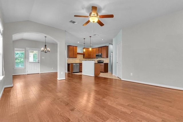 204 Chickadee Ln, Leander, TX 78641 - unfurnished living room featuring a chandelier, ceiling fan, lofted ceiling, arched walkways, and light wood-style flooring
