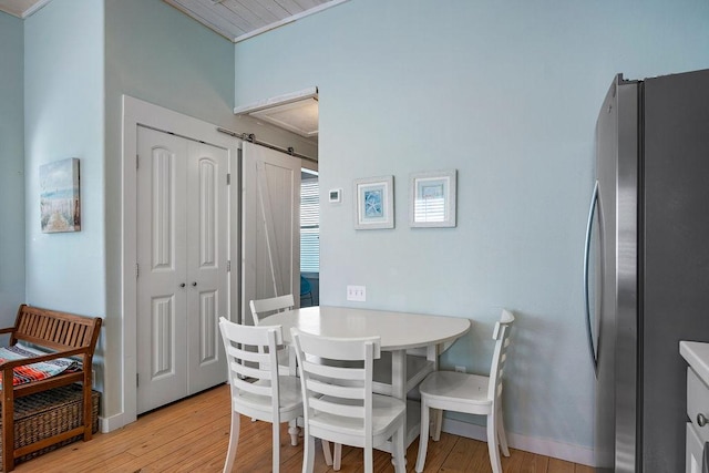 1924 S 11th St Unit 2, Port Aransas, TX 78373 - dining room featuring light wood finished floors, a barn door, and baseboards