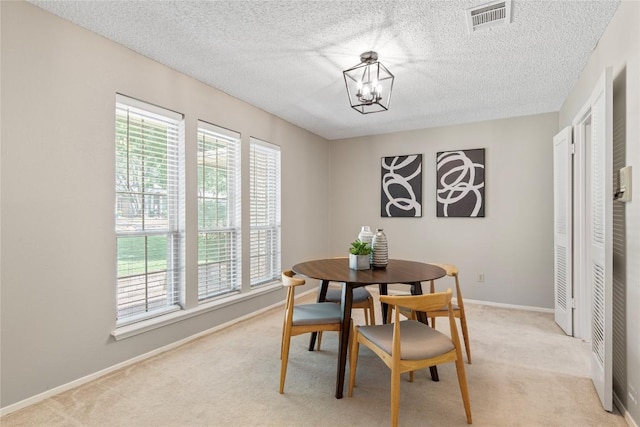 12701 Poquoson Dr, Austin, TX 78727 - dining area featuring healthy amount of natural light, light carpet, a chandelier, a textured ceiling, and baseboards