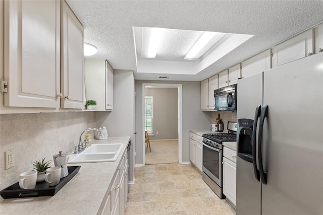 12701 Poquoson Dr, Austin, TX 78727 - kitchen featuring stainless steel appliances, a sink, light countertops, a textured ceiling, and baseboards