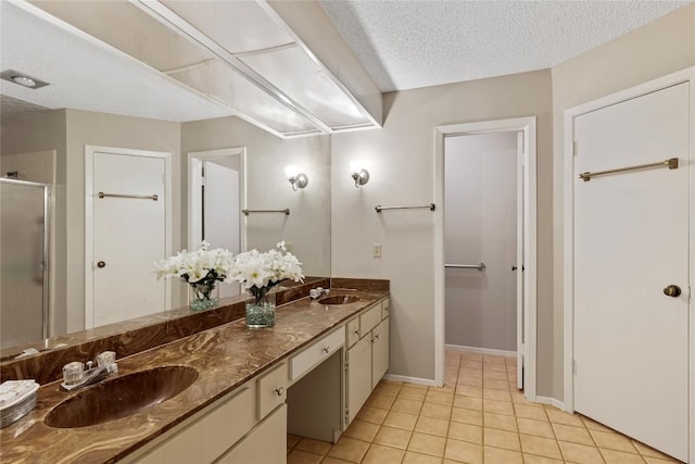 12701 Poquoson Dr, Austin, TX 78727 - bathroom featuring double vanity, a shower stall, tile patterned floors, baseboards, and a textured ceiling