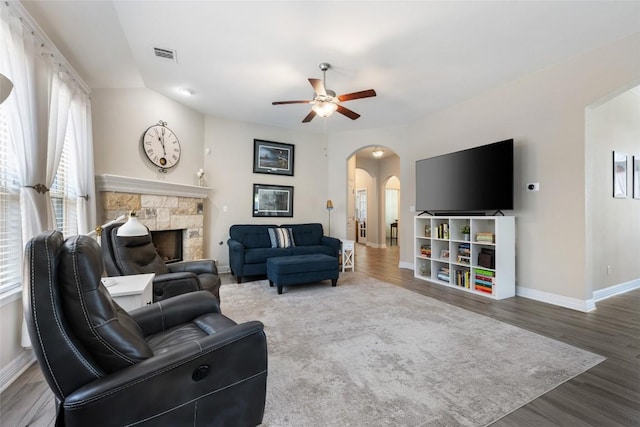 213 Russet Trl, Georgetown, TX 78628 - living area featuring arched walkways, a ceiling fan, baseboards, and a stone fireplace