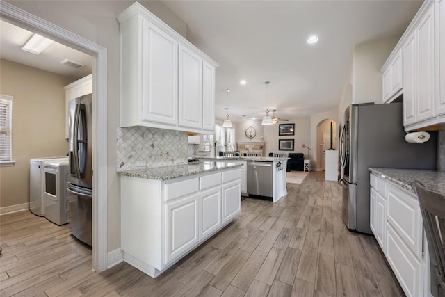 213 Russet Trl, Georgetown, TX 78628 - kitchen featuring washing machine and dryer, stainless steel appliances, open floor plan, white cabinets, and recessed lighting