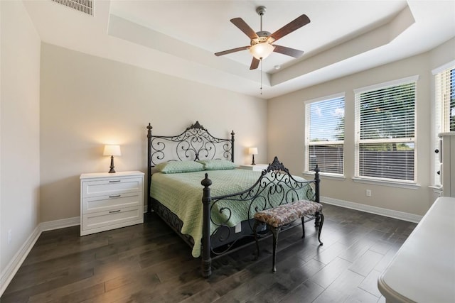 213 Russet Trl, Georgetown, TX 78628 - bedroom with a tray ceiling, baseboards, dark wood-style flooring, and a ceiling fan