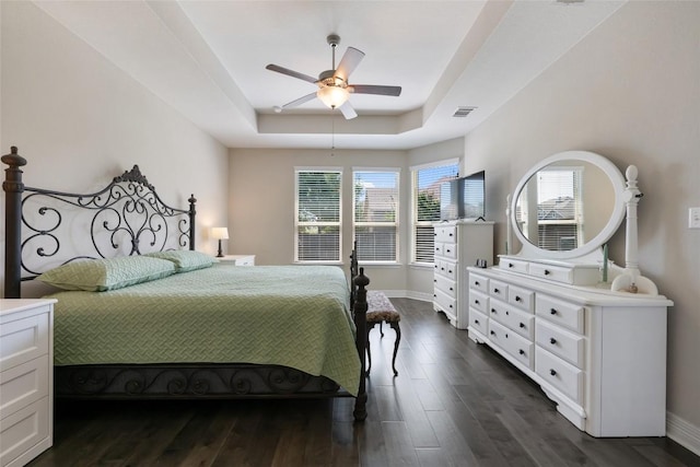 213 Russet Trl, Georgetown, TX 78628 - bedroom featuring a tray ceiling, baseboards, and dark wood finished floors