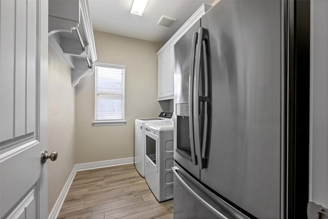 213 Russet Trl, Georgetown, TX 78628 - laundry room with washing machine and dryer, cabinet space, baseboards, and light wood-style floors