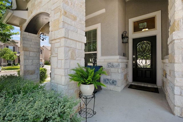 213 Russet Trl, Georgetown, TX 78628 - view of exterior entry featuring stone siding, stucco siding, and covered porch
