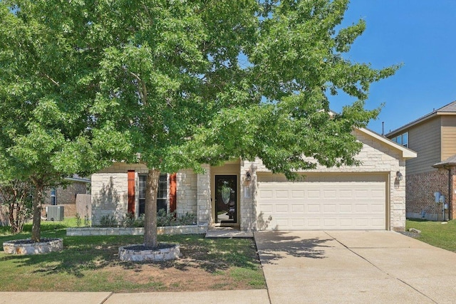 1207 Tricia Cv, Hutto, TX 78634 - view of property hidden behind natural elements with stone siding, an attached garage, central AC unit, and driveway