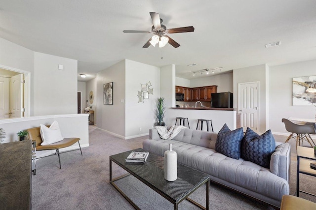 1207 Tricia Cv, Hutto, TX 78634 - living area with ceiling fan, light carpet, and baseboards