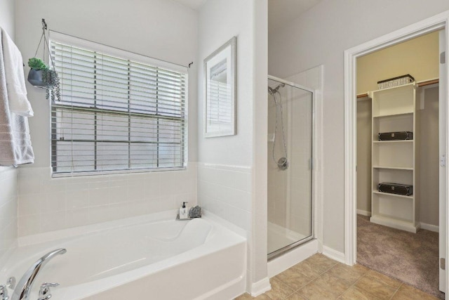1207 Tricia Cv, Hutto, TX 78634 - full bathroom featuring a garden tub, a spacious closet, a stall shower, and healthy amount of natural light