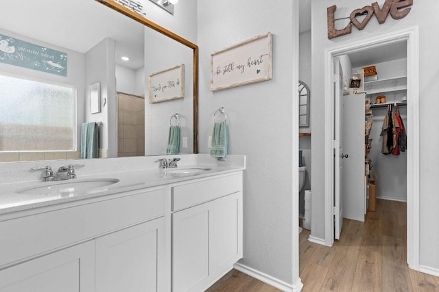 421 Perfect World Loop, Jarrell, TX 76537 - full bath with double vanity, wood finished floors, a walk in closet, and a shower