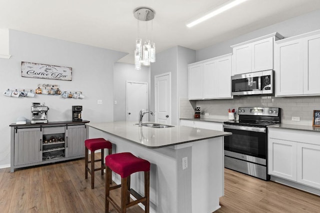 421 Perfect World Loop, Jarrell, TX 76537 - kitchen featuring stainless steel appliances, wood finished floors, decorative backsplash, and a breakfast bar