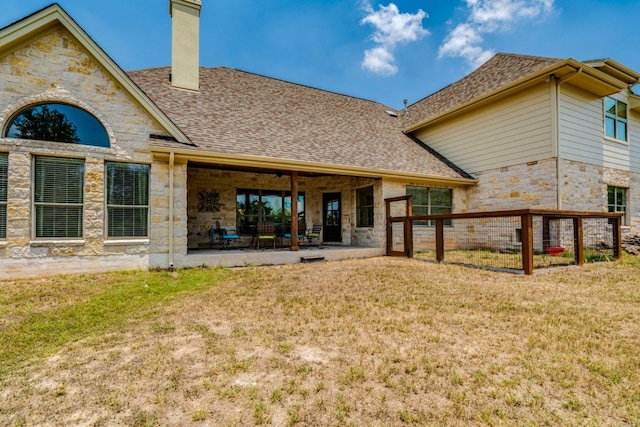 421 Huck Finn Trl, Dripping Springs, TX 78620 - rear view of house featuring stone siding, a chimney, a lawn, and a patio area