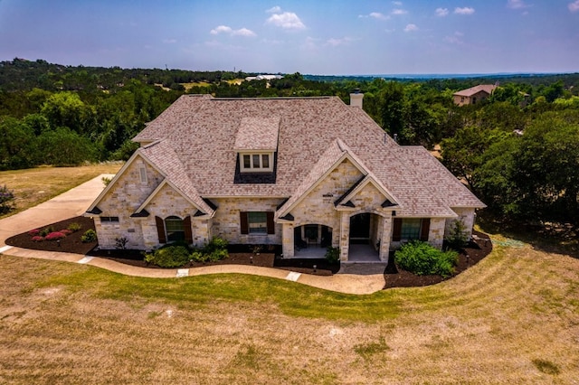 421 Huck Finn Trl, Dripping Springs, TX 78620 - french country inspired facade featuring stone siding, a chimney, and a front lawn