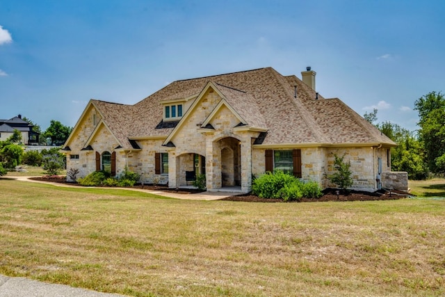 421 Huck Finn Trl, Dripping Springs, TX 78620 - french country style house with stone siding, a front lawn, and a chimney