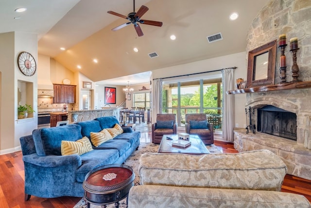 421 Huck Finn Trl, Dripping Springs, TX 78620 - living room featuring high vaulted ceiling, a ceiling fan, a stone fireplace, wood finished floors, and a chandelier