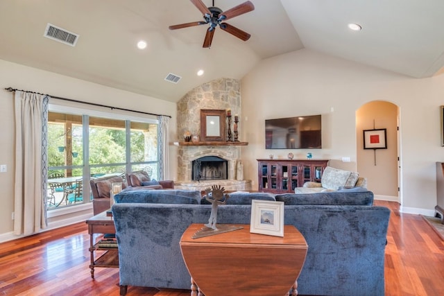421 Huck Finn Trl, Dripping Springs, TX 78620 - living area with vaulted ceiling, a ceiling fan, wood finished floors, a stone fireplace, and baseboards