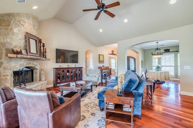 421 Huck Finn Trl, Dripping Springs, TX 78620 - living area featuring arched walkways, a ceiling fan, a fireplace, wood finished floors, and high vaulted ceiling