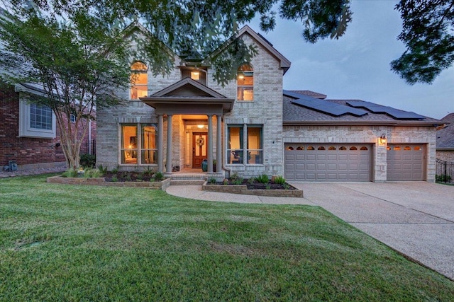 9508 Bully Hill Cv, Austin, TX 78759 - view of front facade featuring an attached garage, solar panels, driveway, a front lawn, and brick siding