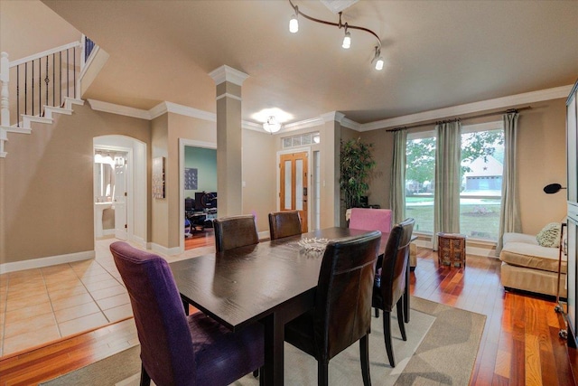 9508 Bully Hill Cv, Austin, TX 78759 - dining area featuring light wood finished floors, crown molding, stairs, arched walkways, and baseboards
