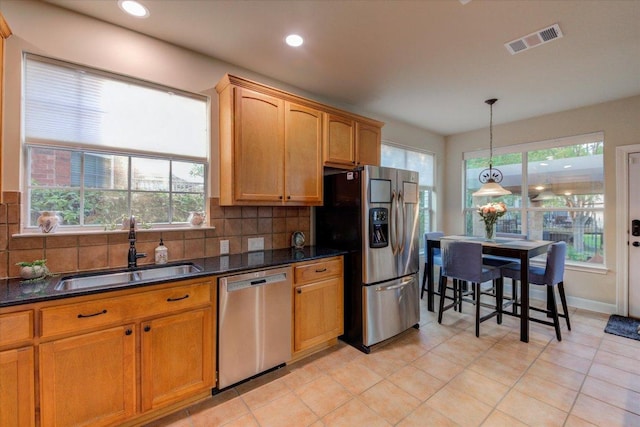 9508 Bully Hill Cv, Austin, TX 78759 - kitchen with appliances with stainless steel finishes, a sink, decorative backsplash, hanging light fixtures, and light tile patterned floors