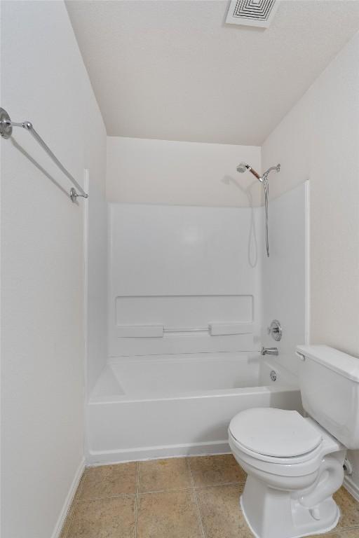 7432 Cayenne Ln, Austin, TX 78741 - bathroom with bathing tub / shower combination, toilet, tile patterned floors, and baseboards