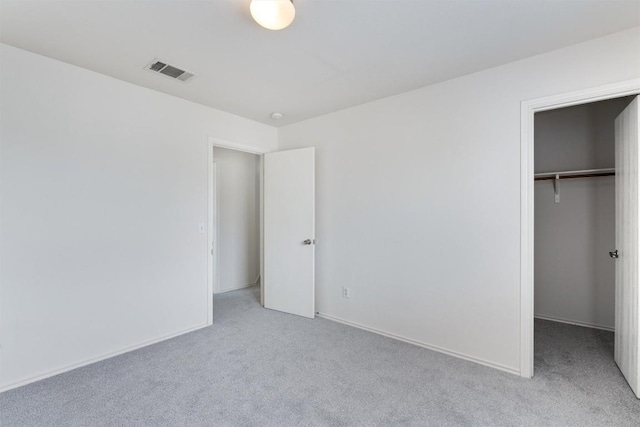 7432 Cayenne Ln, Austin, TX 78741 - unfurnished bedroom featuring light carpet, a closet, and a walk in closet