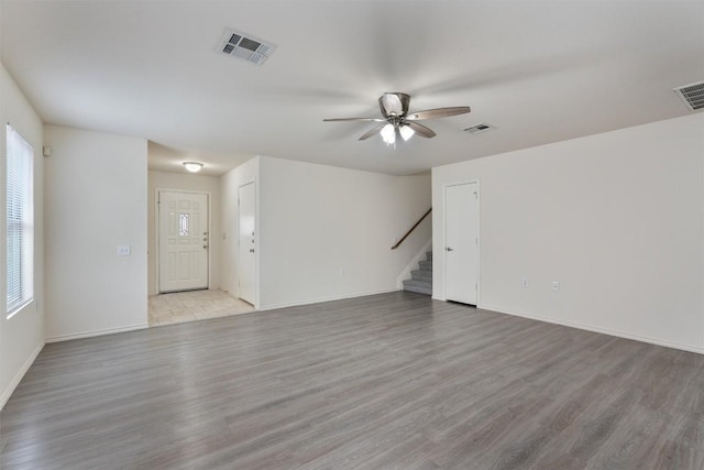 7432 Cayenne Ln, Austin, TX 78741 - unfurnished living room featuring stairs, a ceiling fan, and light wood-type flooring