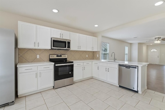 7432 Cayenne Ln, Austin, TX 78741 - kitchen with appliances with stainless steel finishes, a sink, a peninsula, light countertops, and recessed lighting