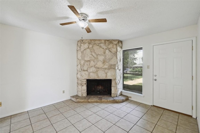 4307 S 1st St Unit 104, Austin, TX 78745 - unfurnished living room with ceiling fan, a textured ceiling, a fireplace, and light tile patterned floors