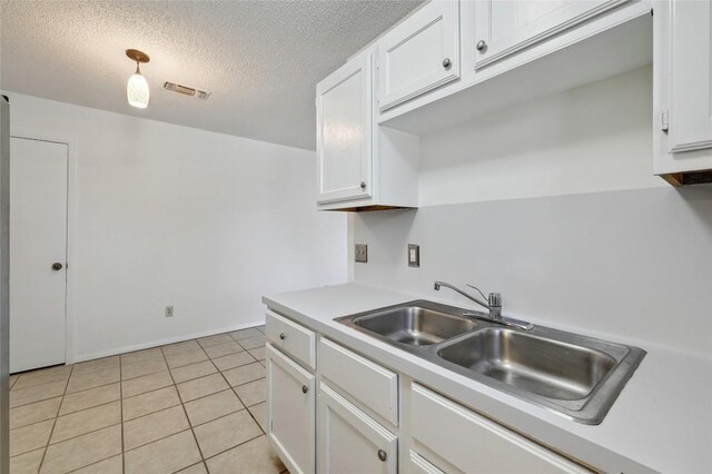 4307 S 1st St Unit 104, Austin, TX 78745 - kitchen featuring white cabinetry, light countertops, a textured ceiling, and light tile patterned flooring